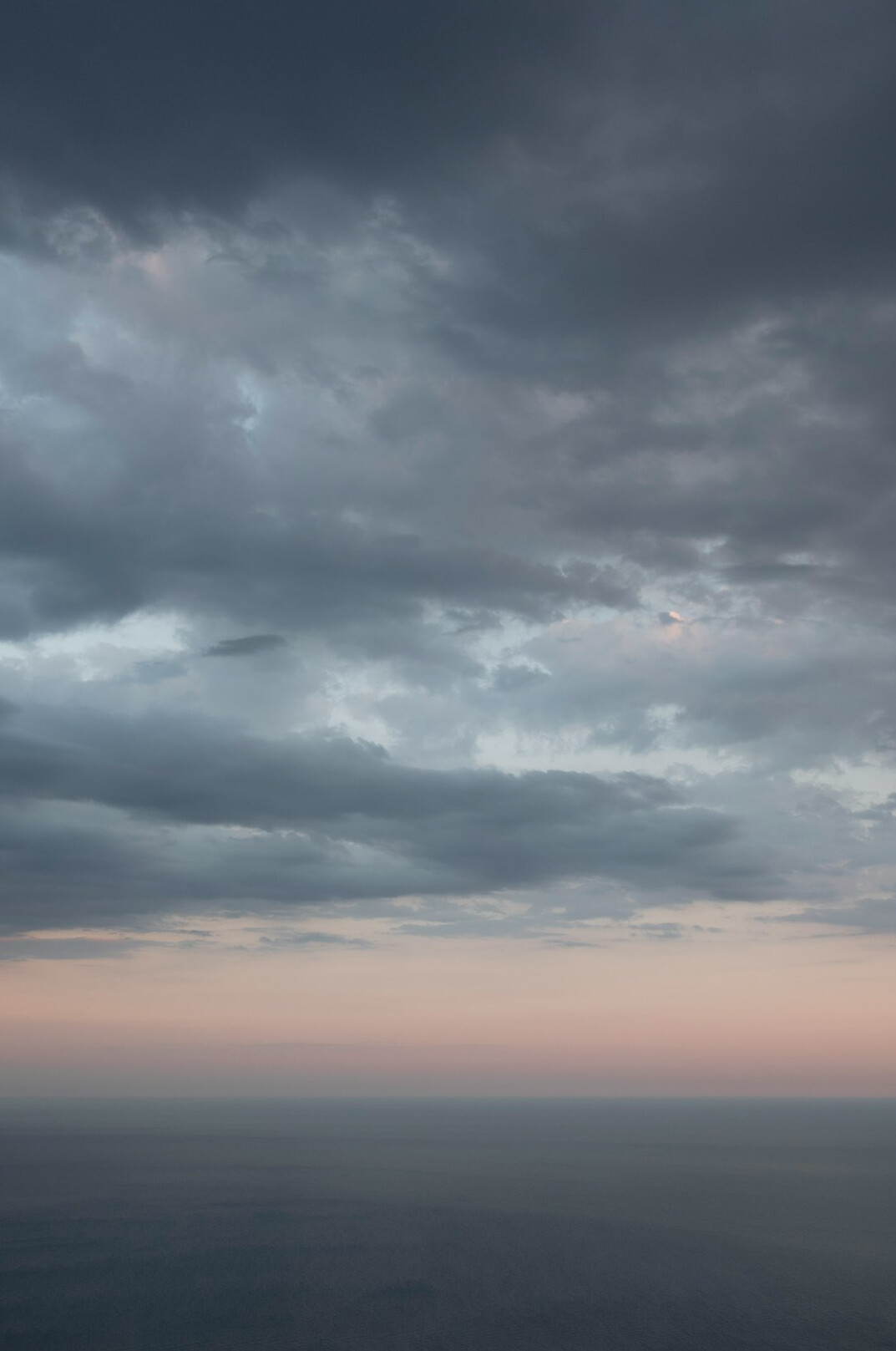 Dark open sea at dusk with low clouds