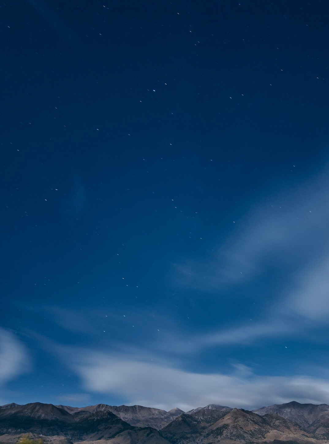 Starry night sky above silent mountains